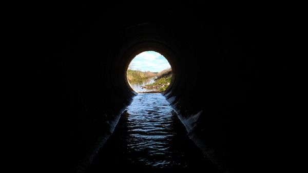 water flowing through large drainage pipe